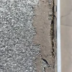 Uszkodzona krawędź dachu żwirowego przy attyce przed naprawą
