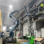 Prace na wysokości z podnośnika koszowego wewnątrz hali produkcyjnej