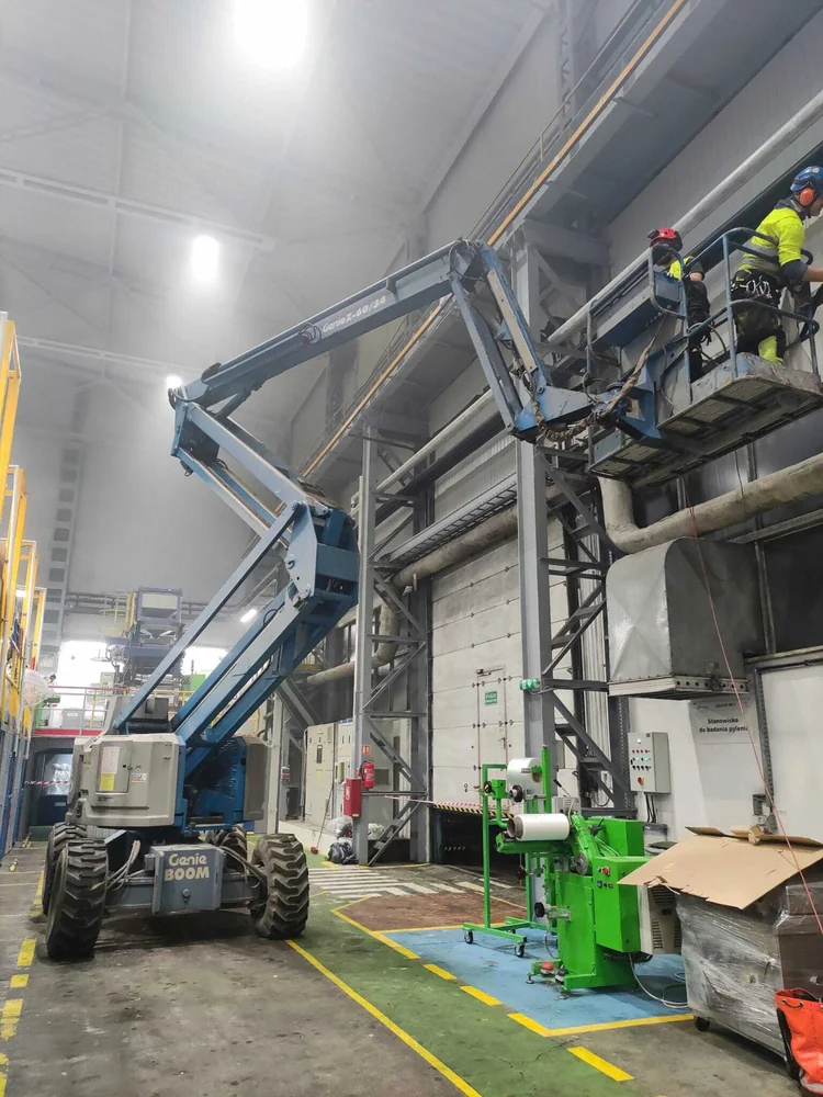 Prace na wysokości z podnośnika koszowego wewnątrz hali produkcyjnej
