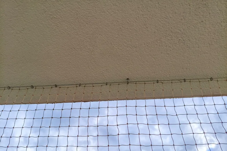 Mocowanie siatki na balkon - haczyki wkręcone w płytę balkonu